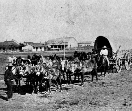 Stagecoach and horses traveling west